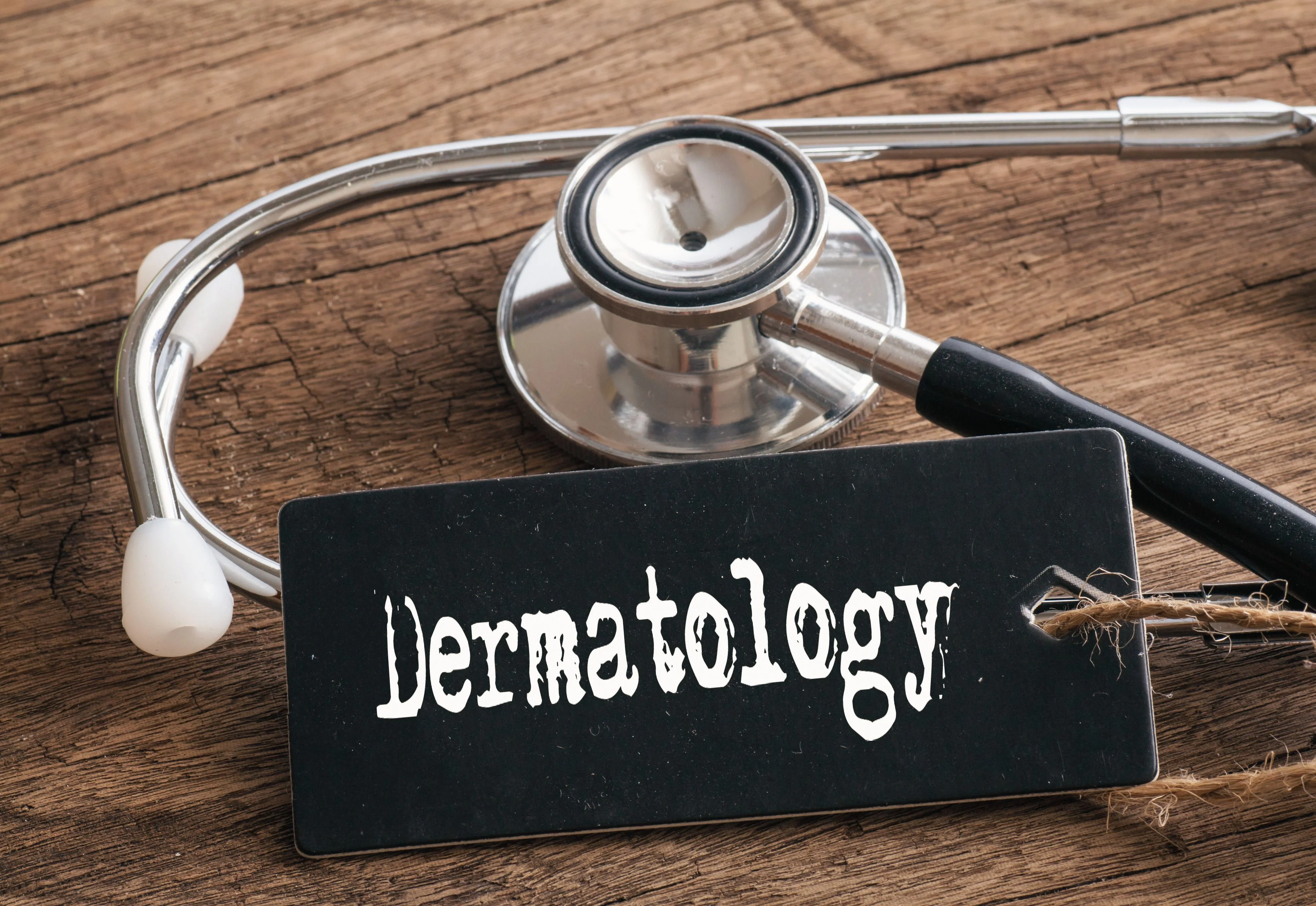A wooden board with a dermatology sign and a stethoscope