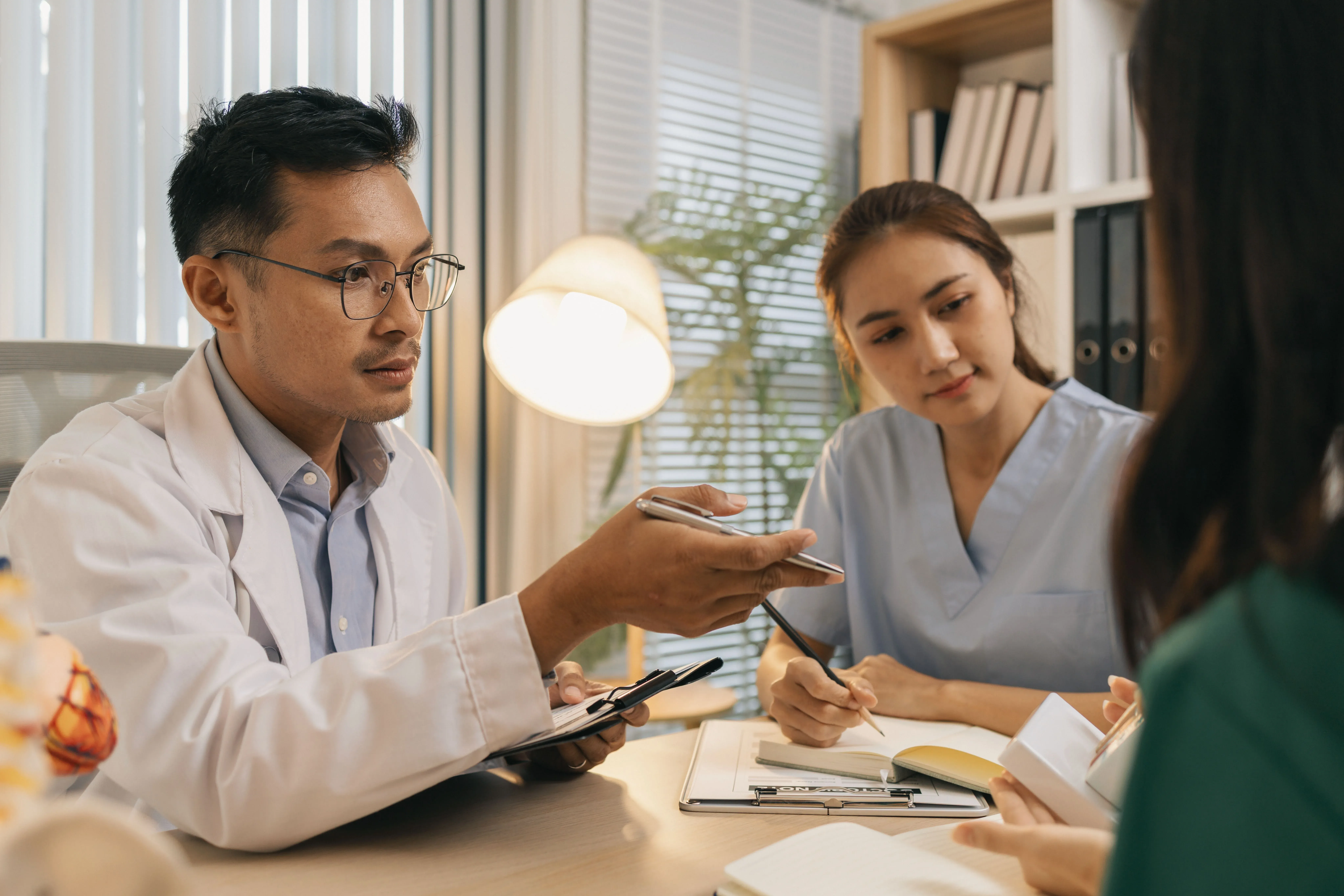 A doctor and a nurse consulting with a patient